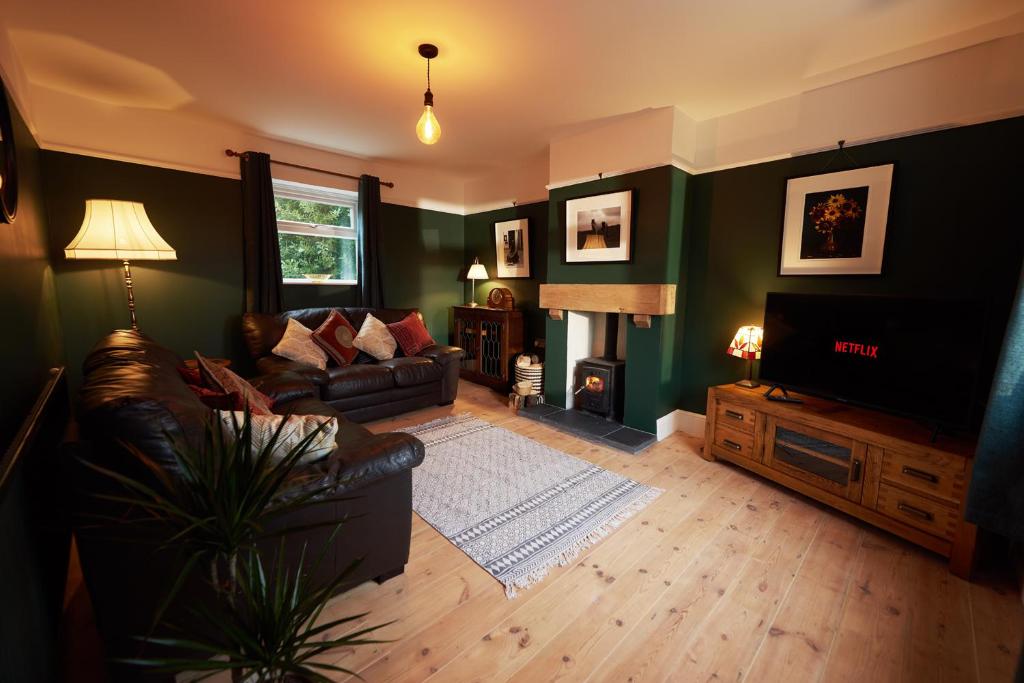 a living room with a couch and a television at Quiet Edwardian era House, Painswick in Painswick