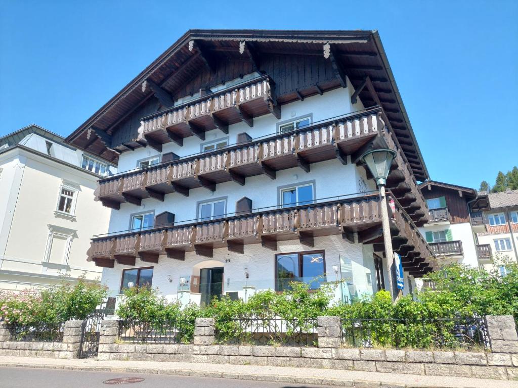 un grand bâtiment blanc avec un toit en bois dans l'établissement Hotel Seerose Wolfgangsee, à Sankt Wolfgang im Salzkammergut