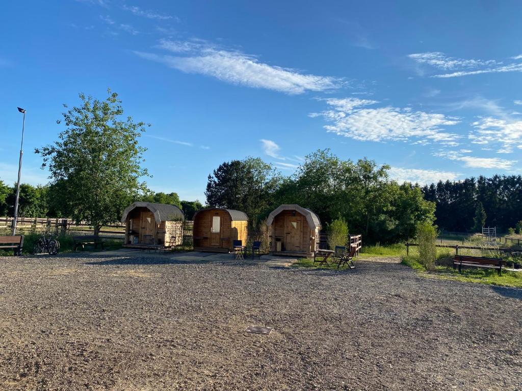 a group of three wooden huts in a field at equi-art Reitanlage in Schwall