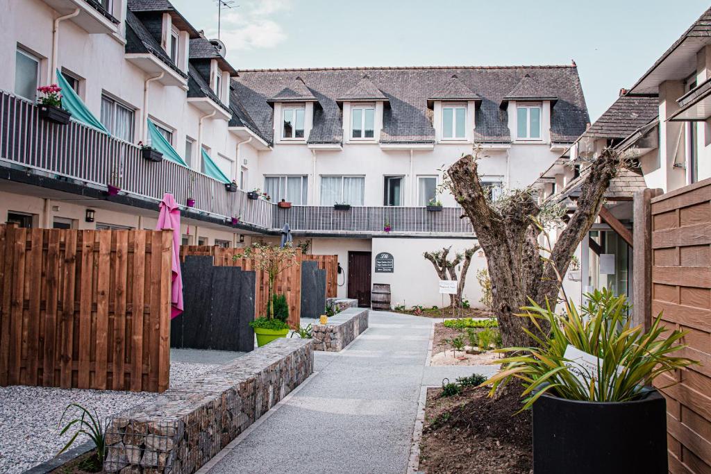 a courtyard of a building with a fence at L'Auberg'ine - Maison Glenn Anna in Sainte Anne d'Auray