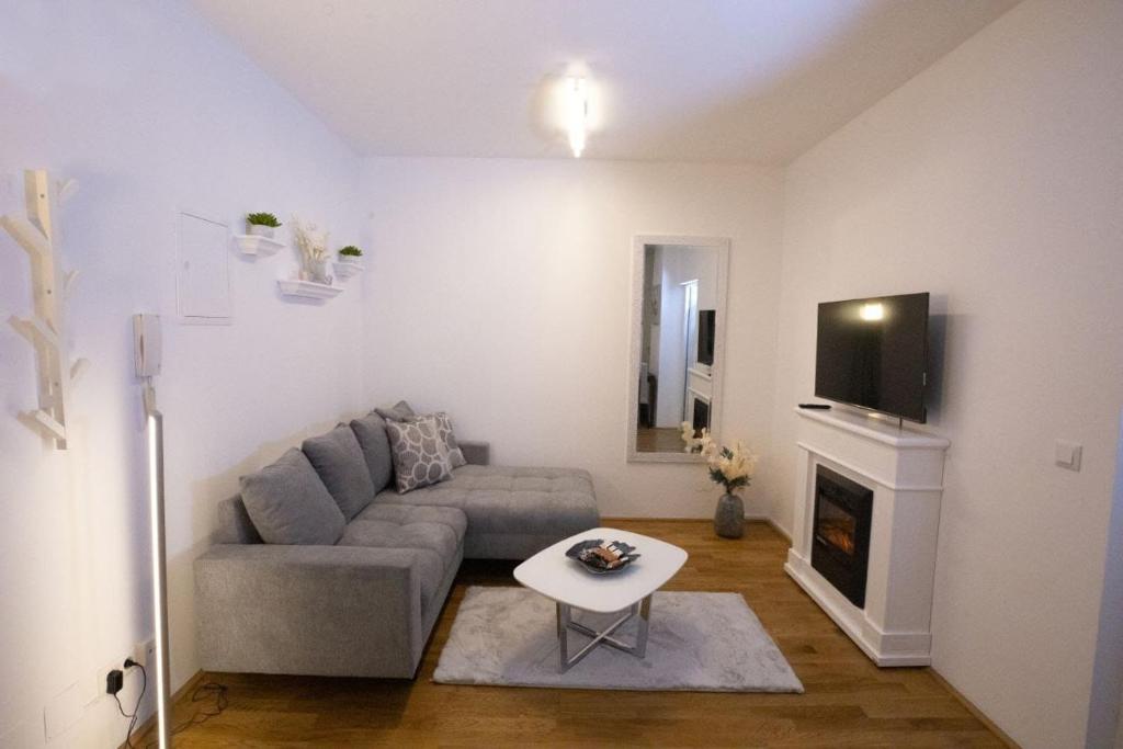 salon z kanapą i telewizorem w obiekcie Stadtjuwel l BG10 w Wiedniu