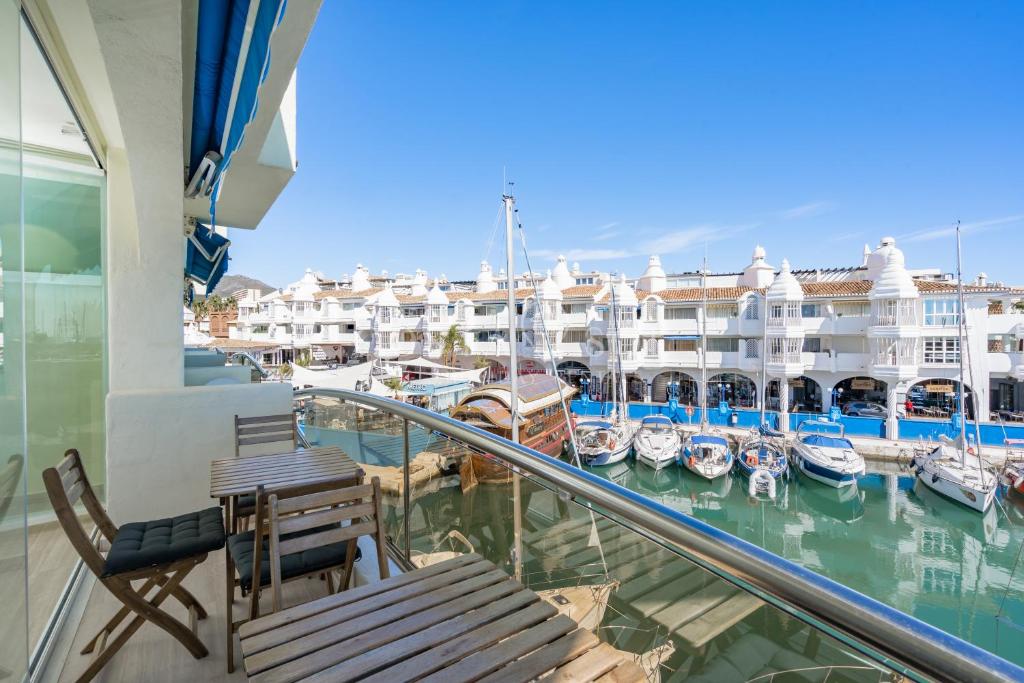 ベナルマデナにあるMalaga Benalmadena Puerto Marina Costa Sol Holiday Rentalsのバルコニー(マリーナ内の椅子とボート付)