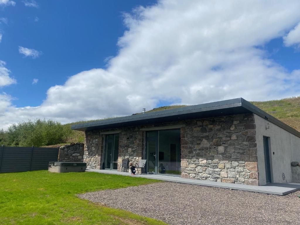 a stone house with a large glass door at Three Lochs View, Ardelve, by Dornie in Dornie