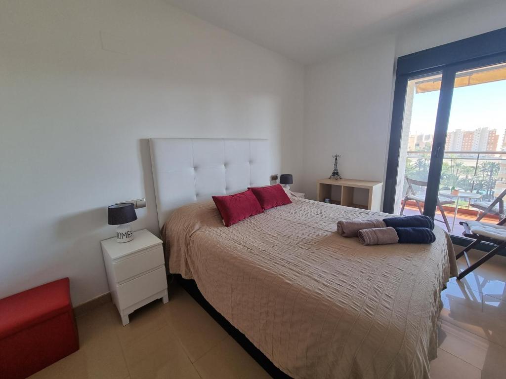 una camera da letto con un grande letto con cuscini rossi di Apartamento con vistas al mar ad Alicante