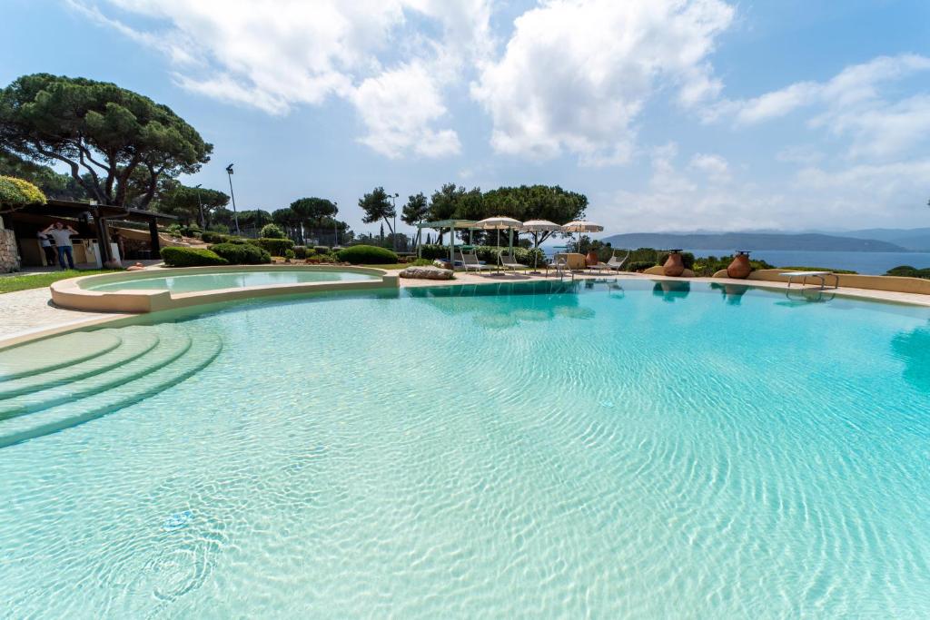 a large swimming pool with blue water at Residence Le Grazie Est in Capoliveri