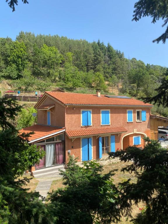 Chassiers的住宿－La Bonne Rencontre，山丘上带蓝色窗户的房子