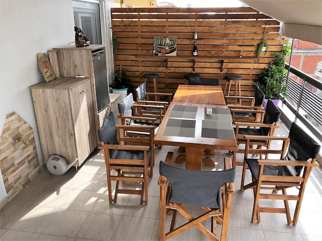 ein Restaurant mit Holztischen und -stühlen auf einem Balkon in der Unterkunft Renovated flat with huge balcony - Ανακαινισμένο διαμέρισμα με τεράστιο μπαλκόνι in Kardítsa