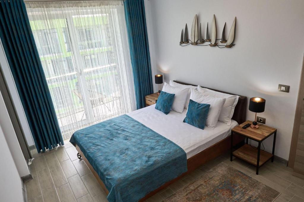 um quarto com uma cama e uma grande janela em Vintage breeze Apartment - Spa Pools resort em Mamaia