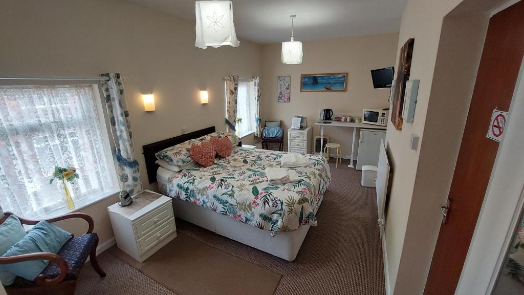 a small bedroom with a bed and a desk at Tennyson Lodge in Mablethorpe