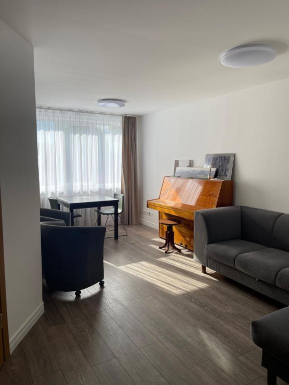 ein Wohnzimmer mit Sofa und Klavier in der Unterkunft APARTMENTS IN THE CITY CENTER BIRŽAI Vytauto g22 in Biržai