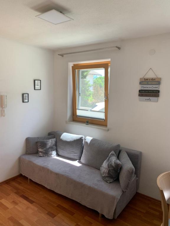 un sofá en una sala de estar con ventana en Haus Helga, en Lienz