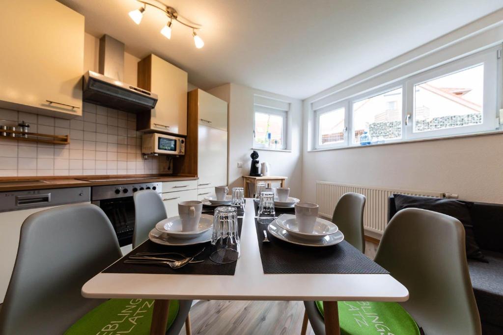 a dining room table with chairs and a kitchen at Ferienwohnung-Auszeit-im-Schwarzwald in Schwanau