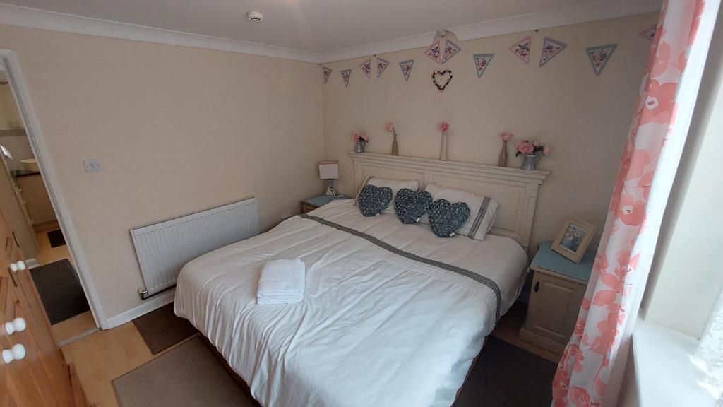 a bedroom with a large white bed with blue pillows at Tennyson Lodge in Mablethorpe