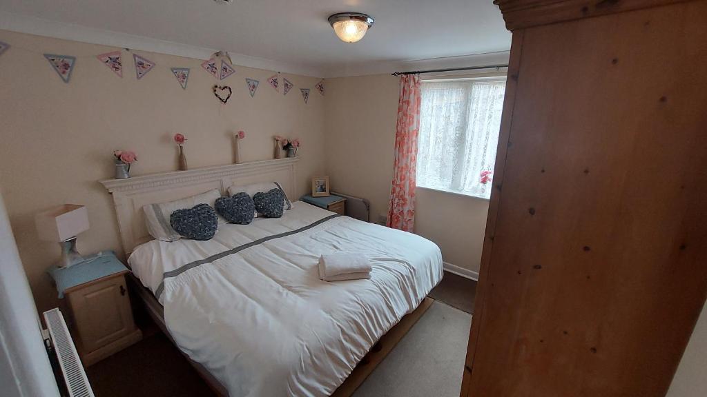 a bedroom with a white bed and a window at Tennyson Lodge in Mablethorpe