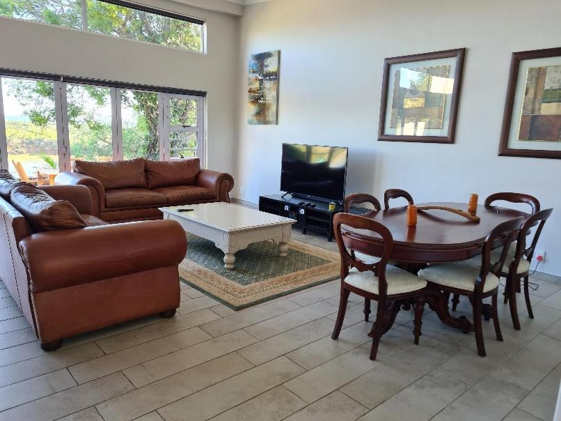 uma sala de estar com uma mesa e um sofá em 10 on Aquavista Addo River View Villa em Colchester