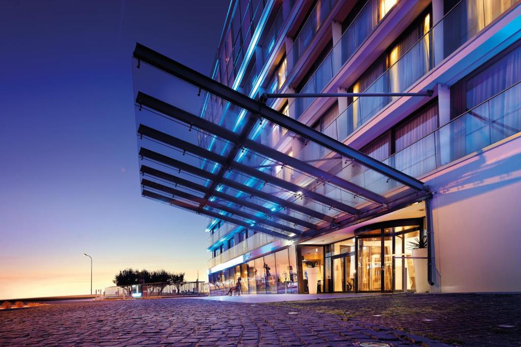 duży budynek ze szklaną fasadą z oświetleniem w obiekcie Marine Hotel by Zdrojowa w Kołobrzegu