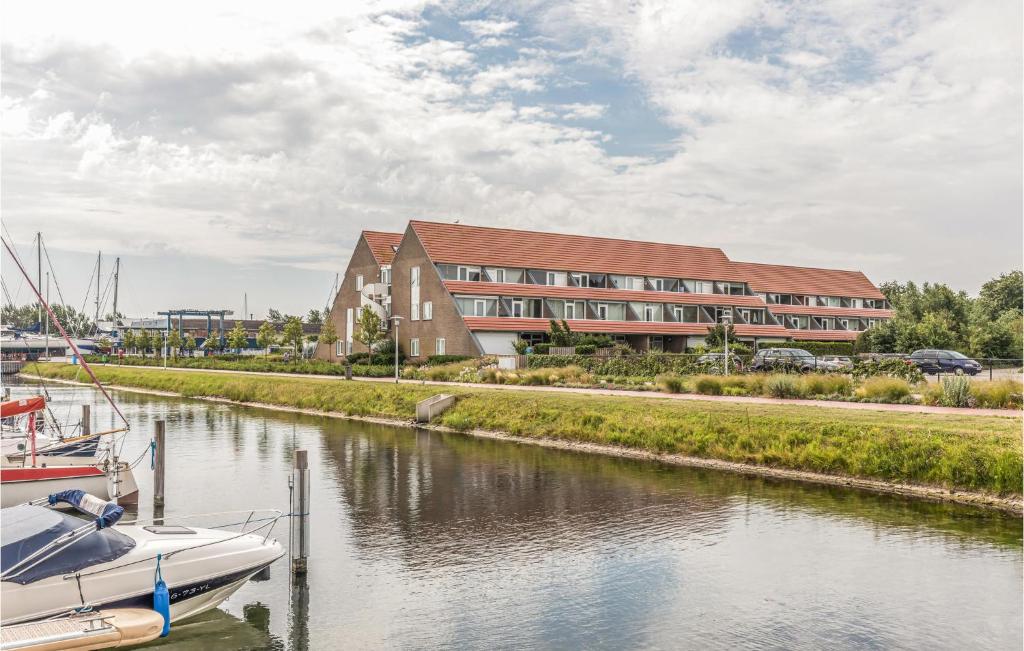 un edificio junto a un río con un barco en el agua en Cozy Home In Bruinisse With Wifi, en Bruinisse