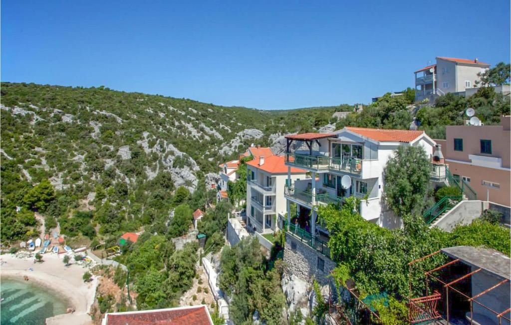 a house on a hill next to a beach at Stunning Apartment In Vinisce With Wifi And 2 Bedrooms in Vinišće