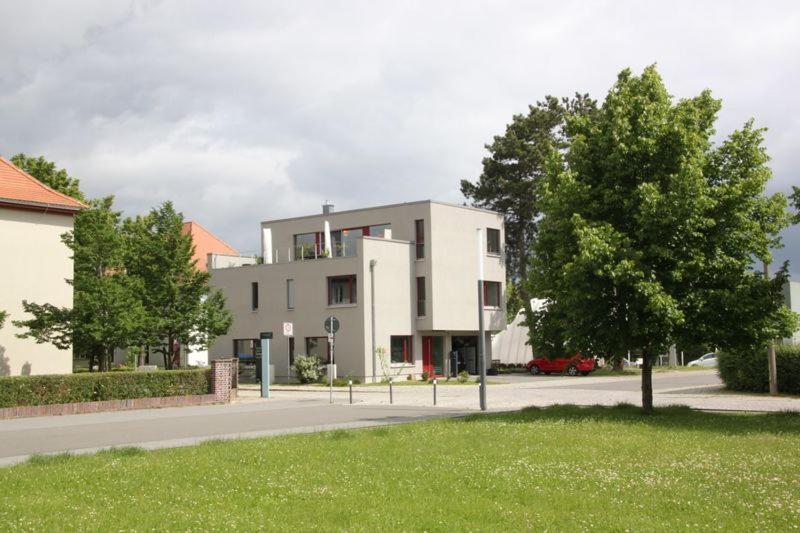 ein großes weißes Gebäude an der Straßenseite in der Unterkunft Appartements am Bauhaus in Dessau