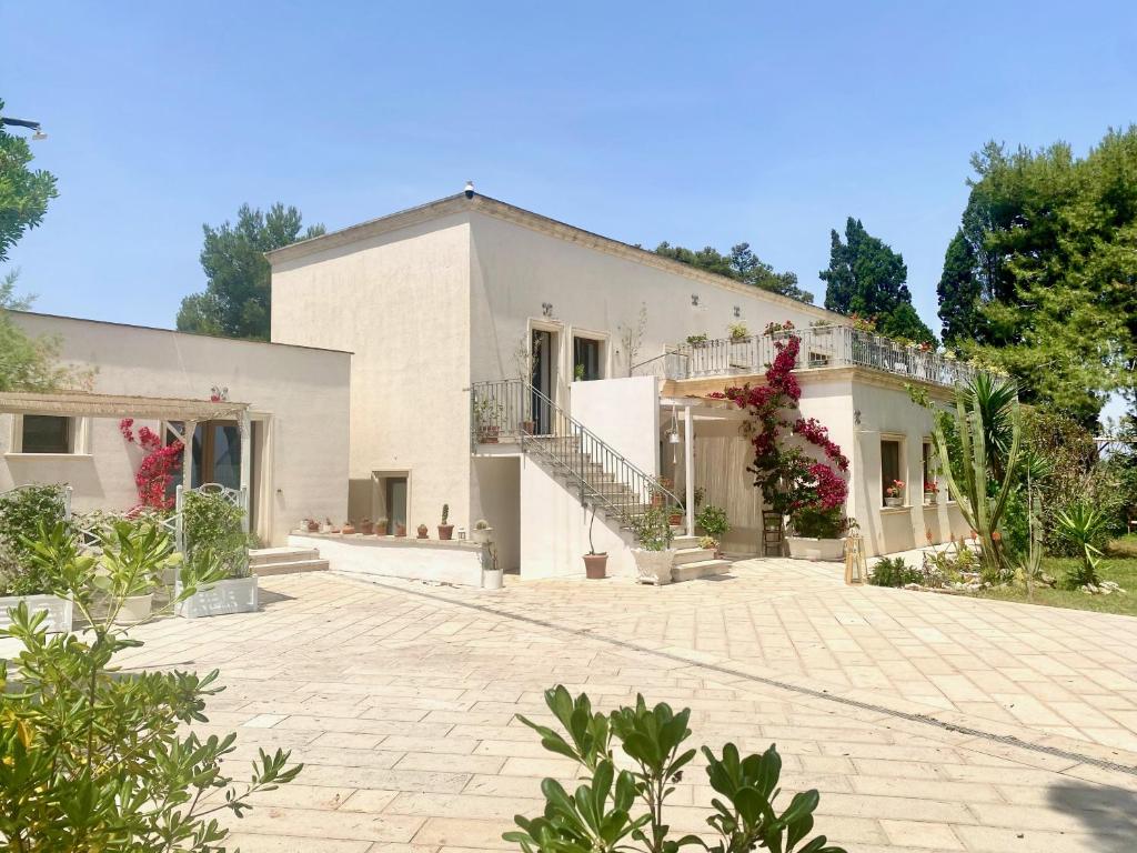 a large white house with a brick driveway at La Dimora di Ulisse in Santa Cesarea Terme