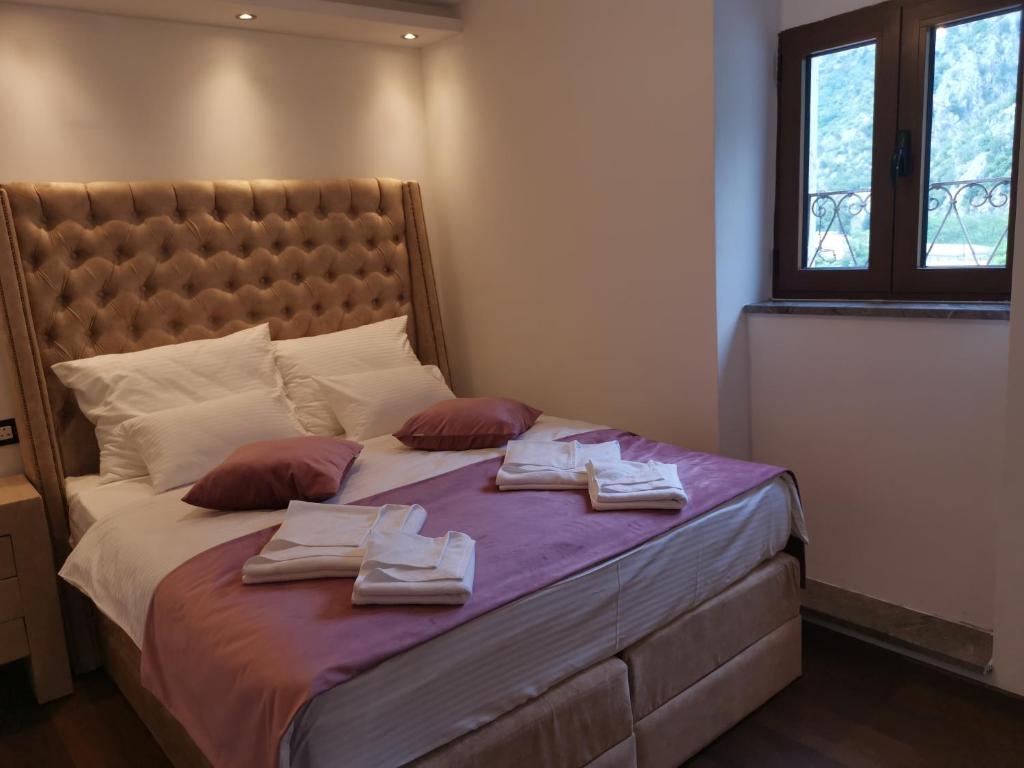 1 dormitorio con 1 cama con toallas en I&G APARTMENTS, en Kotor