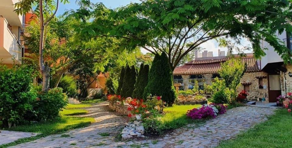 un jardín con una casa y algunas flores y árboles en H by Hambar, en Vama Veche