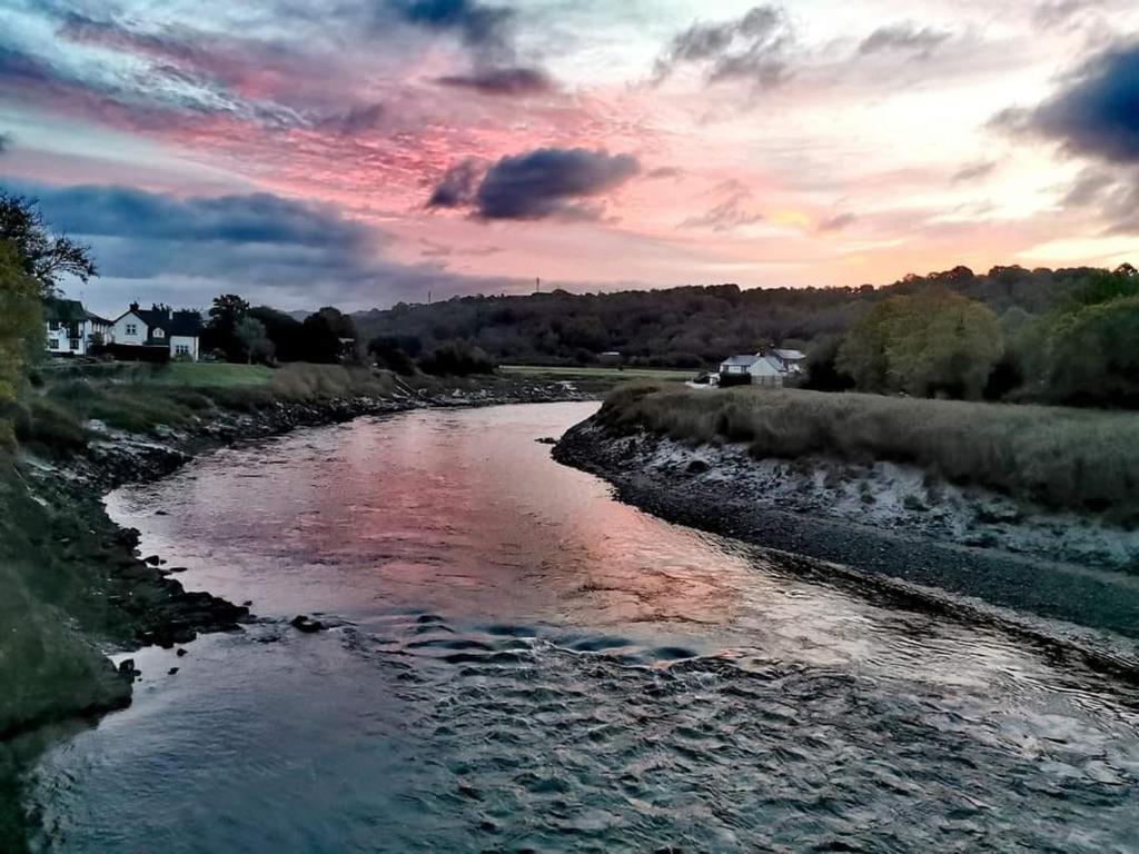 a river with a cloudy sky in the background at Quaint little guest suite with private parking in Newport