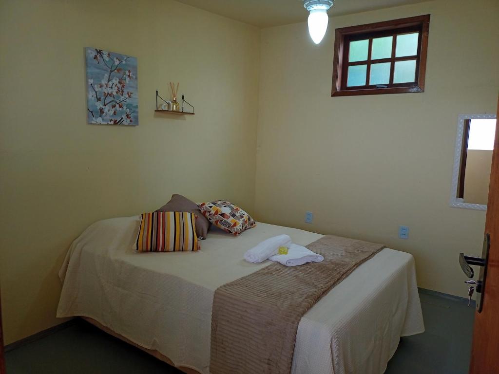 um quarto com uma cama com duas toalhas em Hostel Guaratiba Casa do Café em Barra de Guaratiba