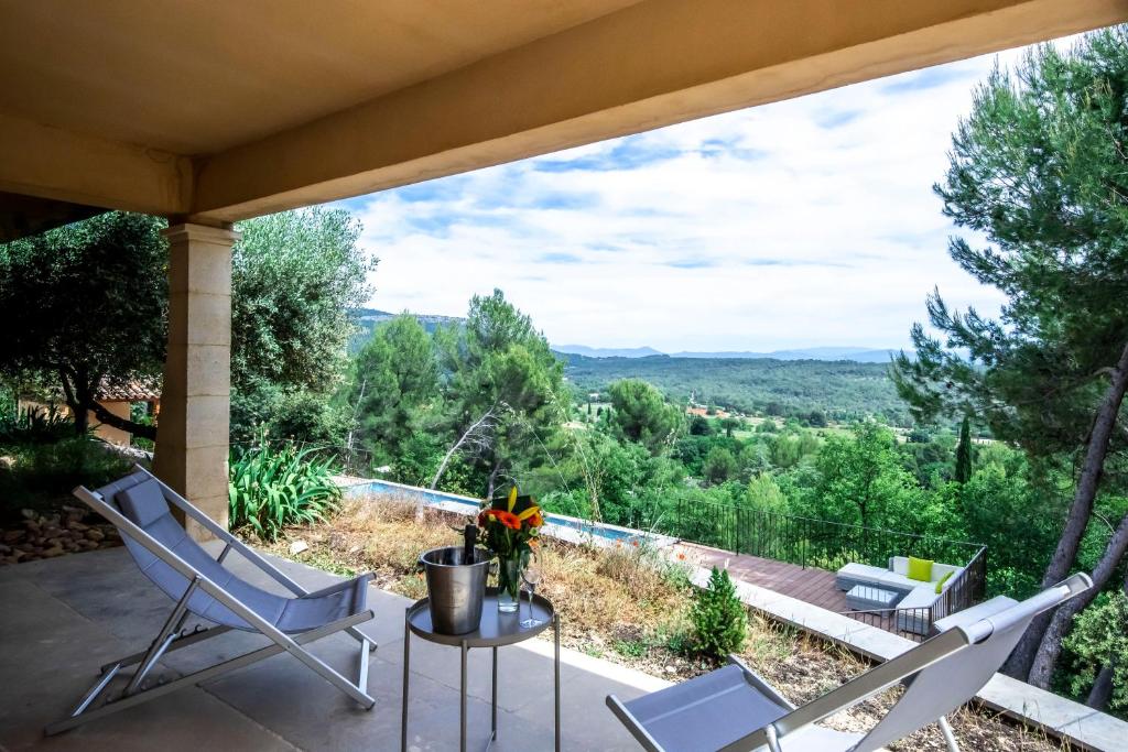 d'une terrasse avec des chaises et une table offrant une vue. dans l'établissement Studio Panoramic with the pool near Saint Victoire Aix en Provence, au Tholonet