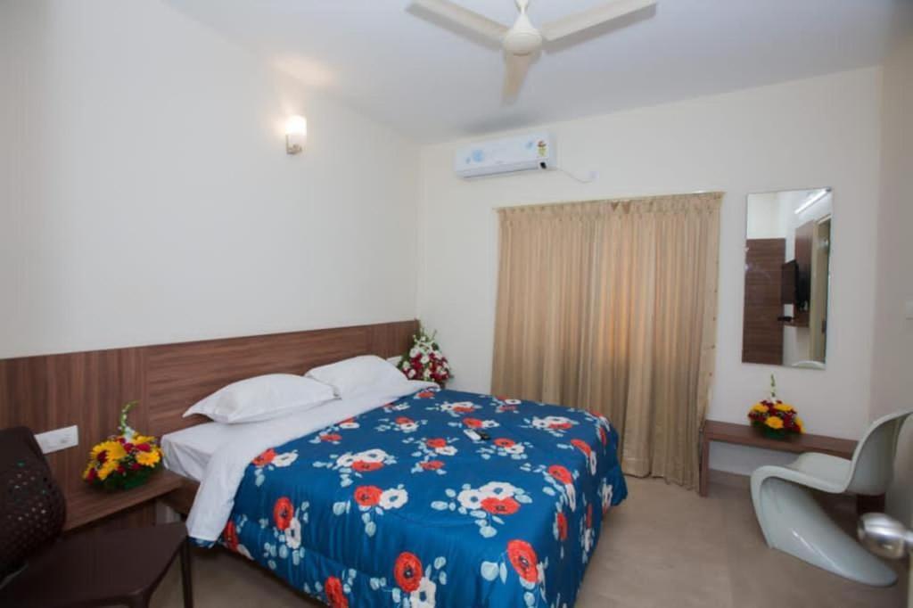 Un dormitorio con una cama con un edredón azul. en HOTEL VIJAYA LAKSHMI RESIDENCY - YESHWANTHPUR, en Bangalore