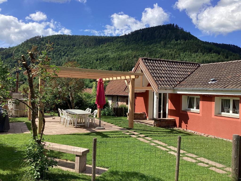 een huis met een picknicktafel in de tuin bij Gîte le Cerf Volant in Raon-sur-Plaine