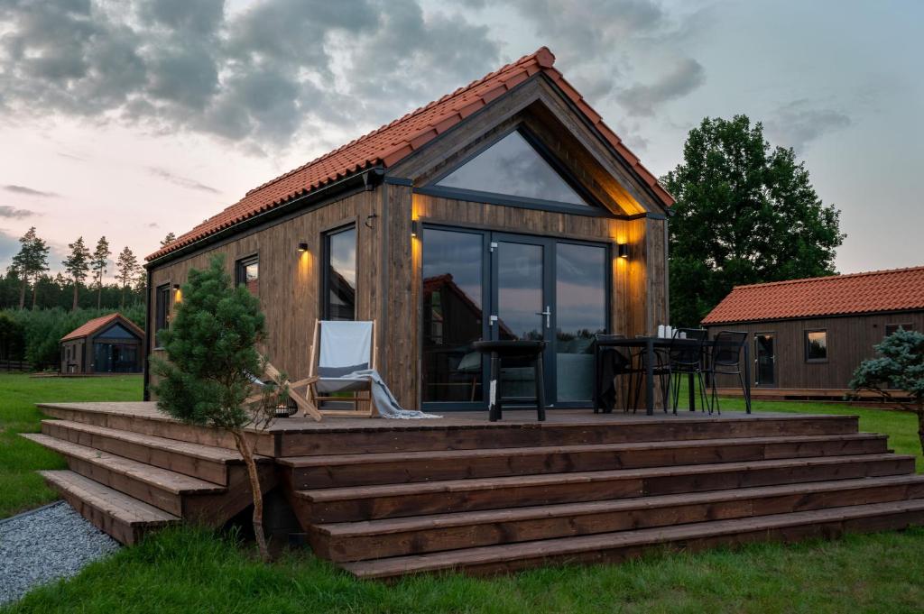 a tiny house with a deck and a table at Mazurskie Hytte in Łukta