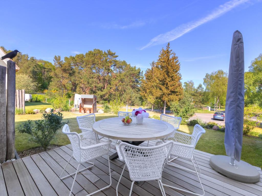 patio con tavolo e sedie su una terrazza di Ferienhaus Fritz Reethus mit Sauna und Kamin a Loddin