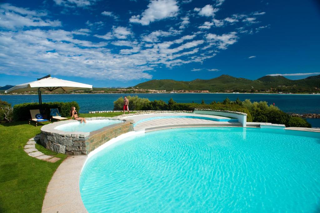 una grande piscina con vista sull'acqua di Hotel Palumbalza Porto Rotondo a Porto Rotondo