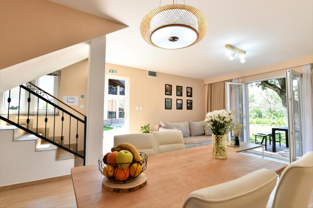 uma sala de estar com uma mesa com uma taça de fruta em Apartments Green Linden em Rakovica