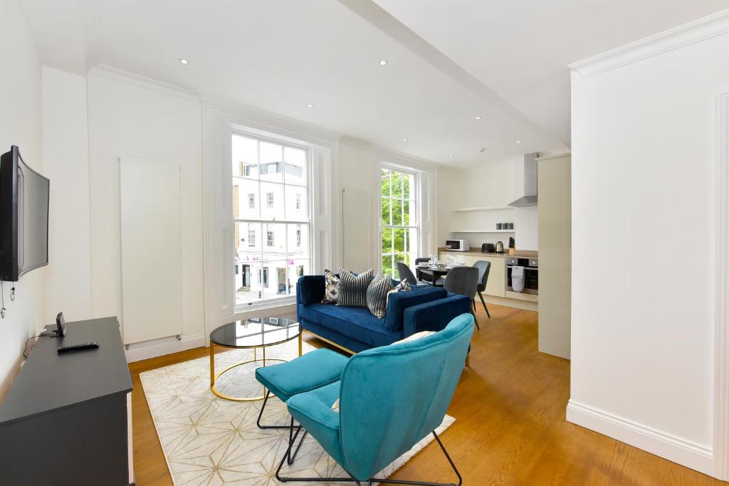 uma sala de estar com um sofá azul e uma mesa em London Choice Apartments - Chelsea - Sloane Square em Londres