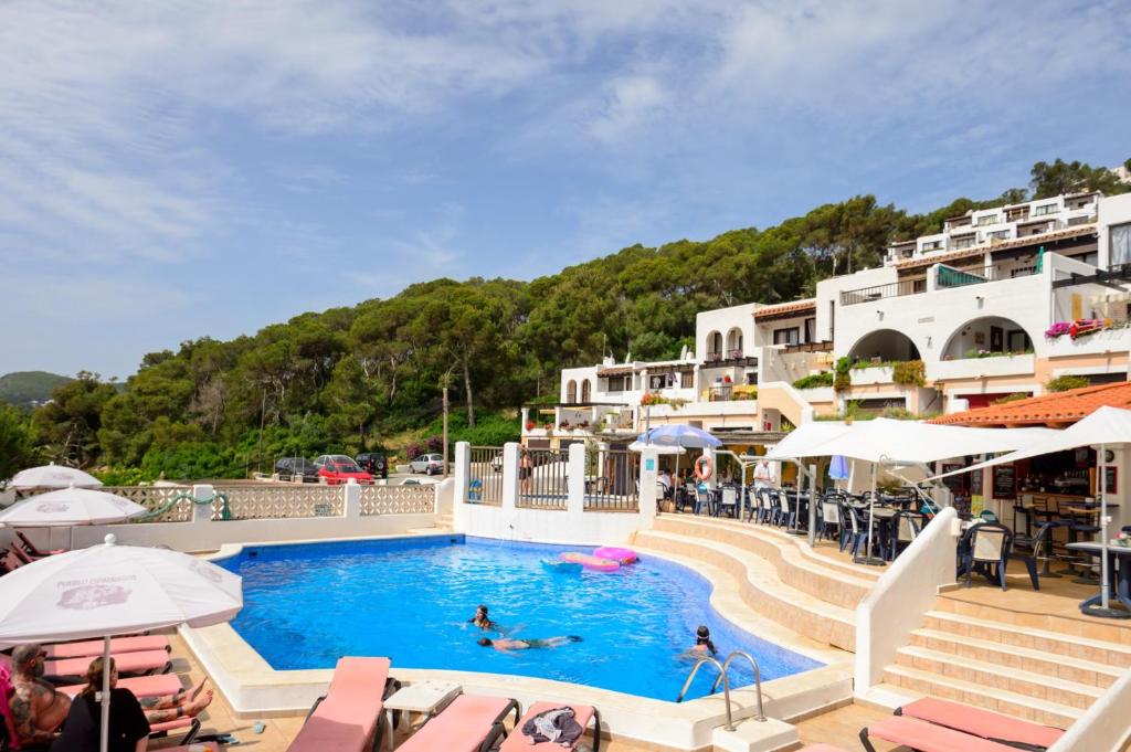 a pool at a resort with people swimming in it at Casita en Cala Llonga in Cala Llonga
