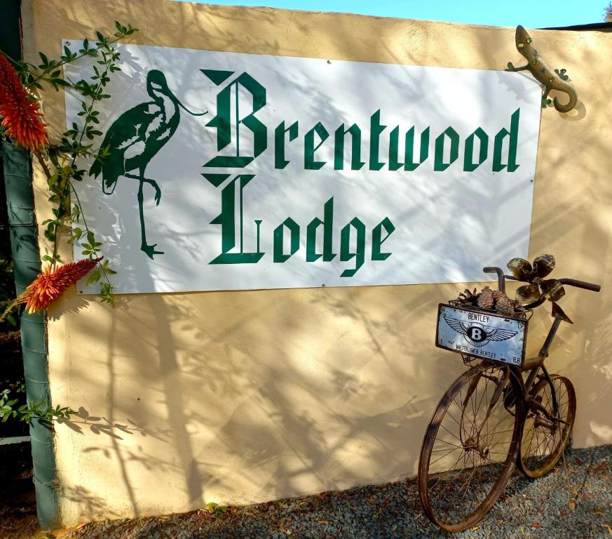 Deneysville的住宿－Brentwood Lodge，一辆自行车停在屋顶小屋前的标志