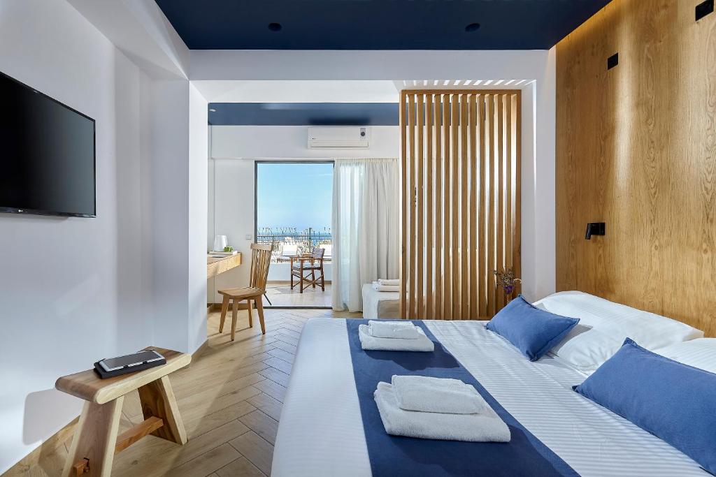 a bedroom with a large bed with blue pillows at Arminda Hotel & Spa in Hersonissos