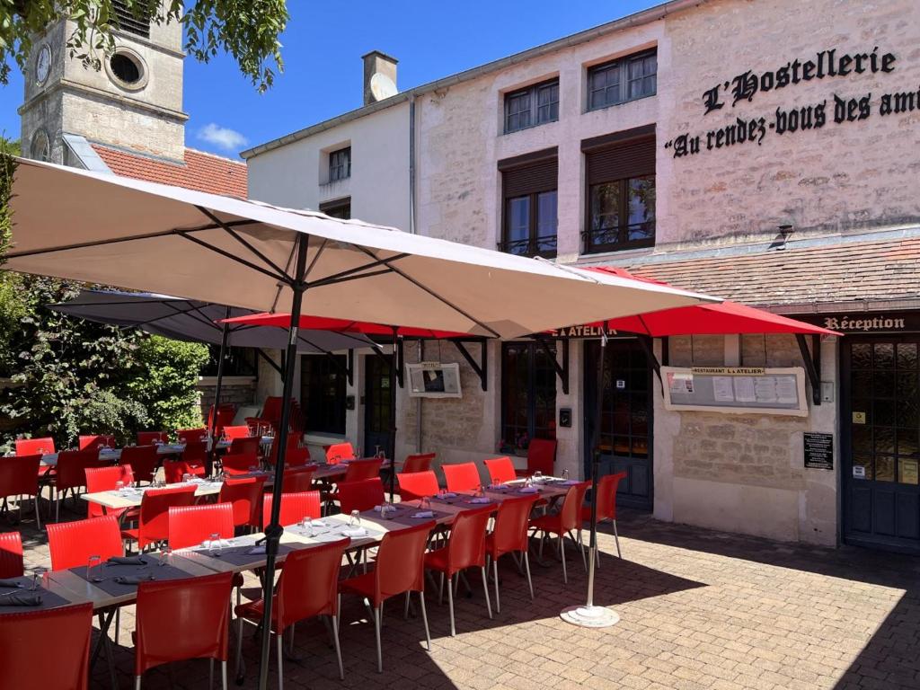 um grupo de mesas e cadeiras sob um guarda-sol em Hostellerie Au rendez-vous des amis em Chaumont