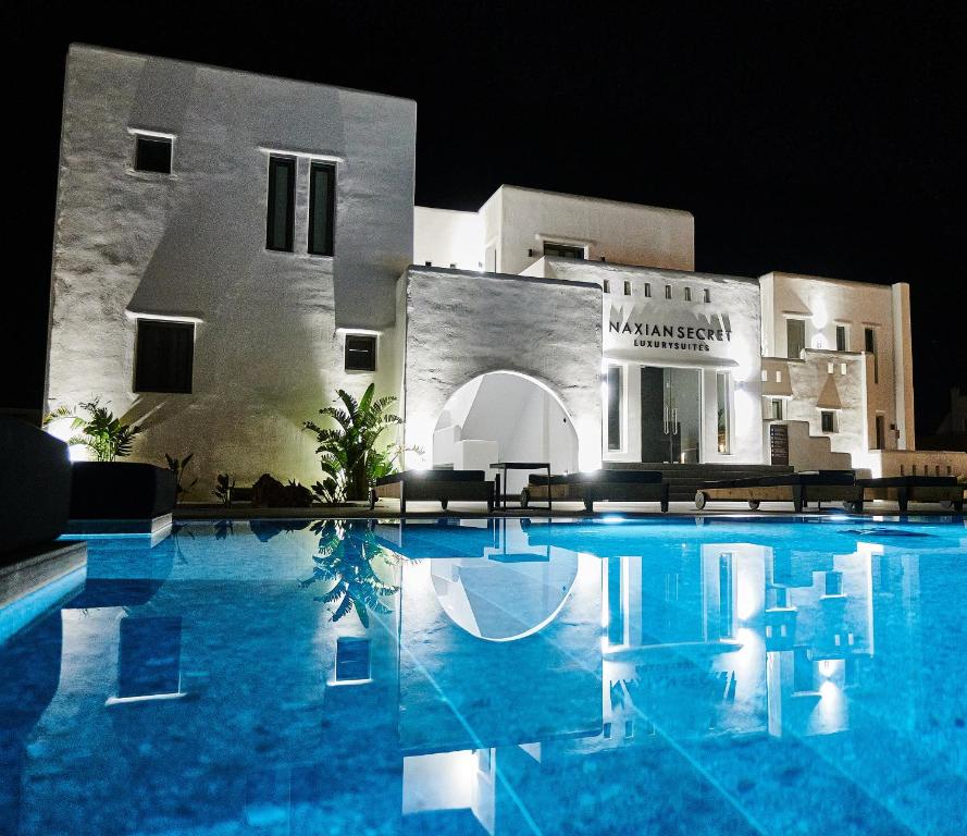 a swimming pool in front of a building at night at Naxian Secret in Naxos Chora