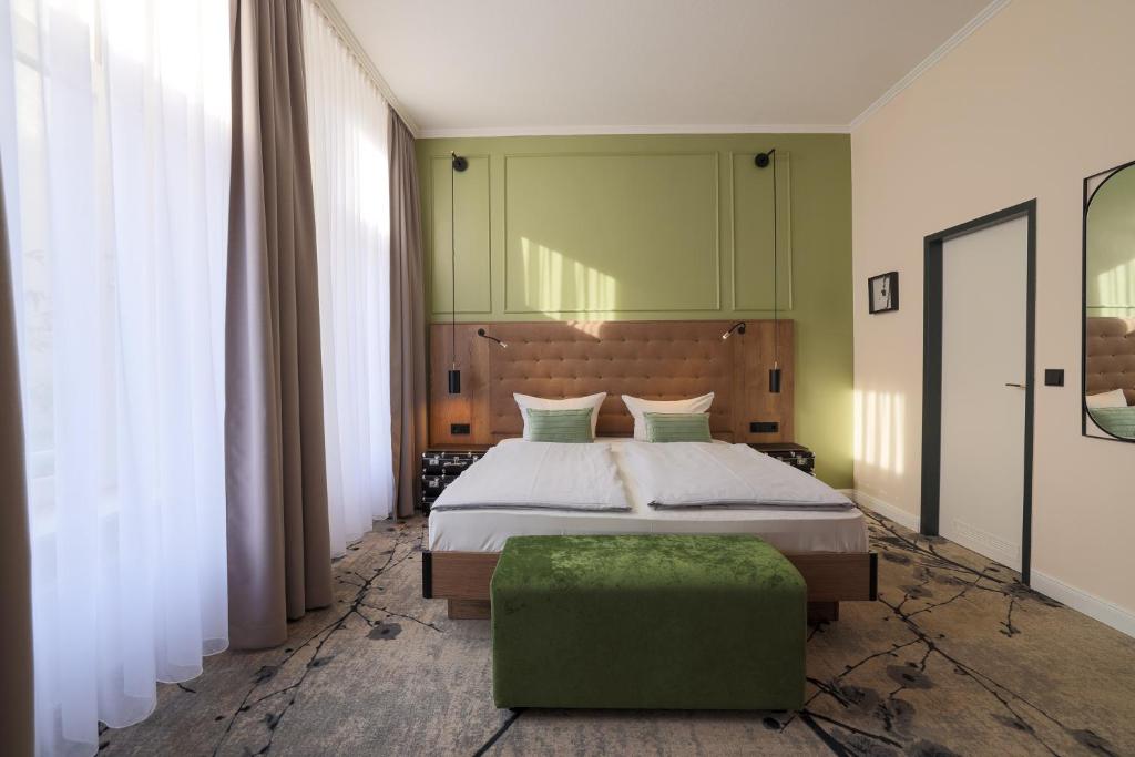 a bedroom with a bed and a green wall at LIHO - einfach Lübeck in Lübeck