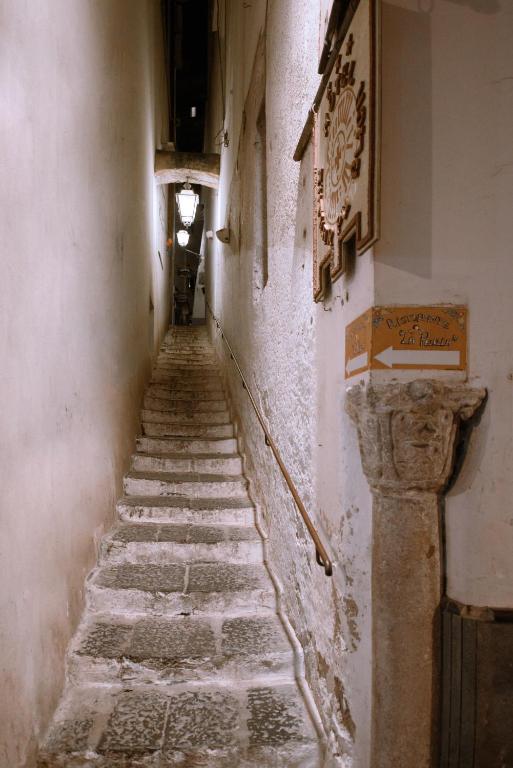 an alleyway in an old building with stone stairs at Amalfi Suite Boutique Hotel in Amalfi