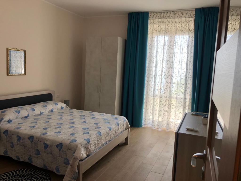 a bedroom with a bed and a large window at Case Pagano Mare in Taormina