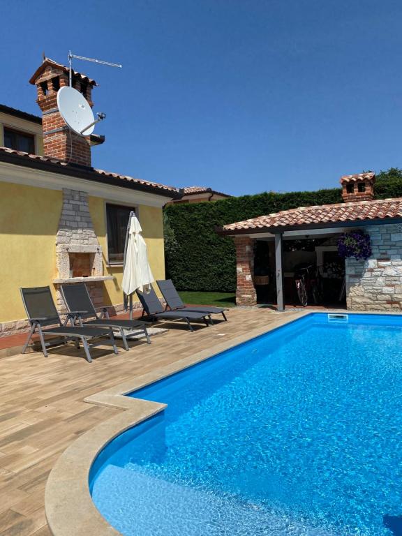a swimming pool in front of a house at Villa Eva Karigador in Novigrad Istria
