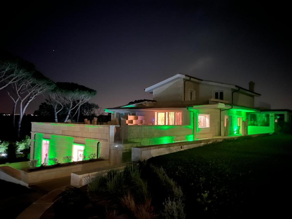 una casa con luces verdes encendidas por la noche en Euphoria Resort en Olgiata