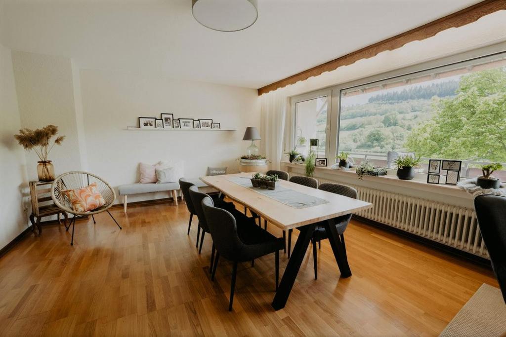 a living room with a table and chairs and a large window at Ferienhaus Anni in Zell an der Mosel
