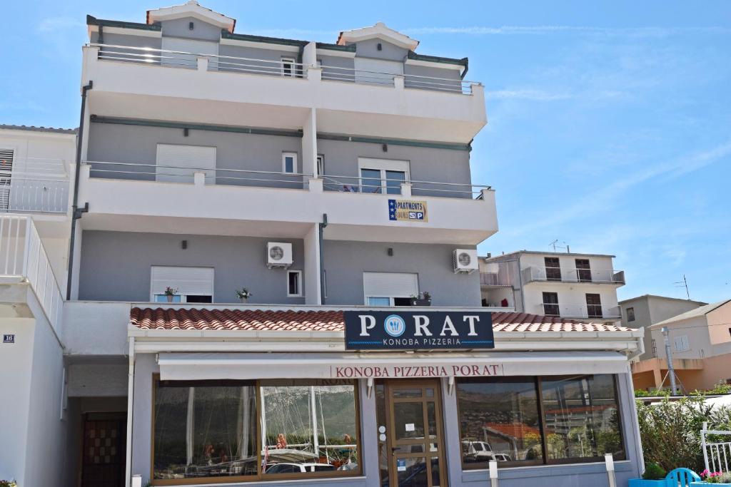 un grand bâtiment blanc avec un panneau indiquant un restaurant dans l'établissement Rooms and Apartments Porat, à Split