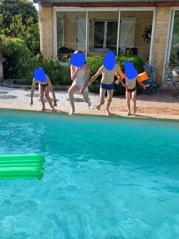 un groupe de personnes sautant dans une piscine dans l'établissement Villa de vacances avec piscine chauffée proche d Anduze, à La Barriére