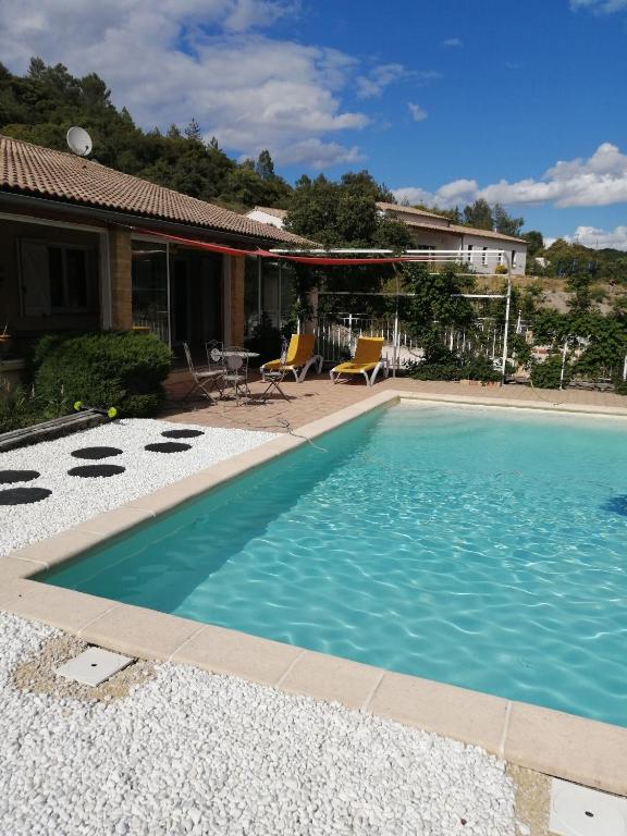 a swimming pool in front of a house at Villa de vacances avec piscine chauffée proche d Anduze in La Barriére